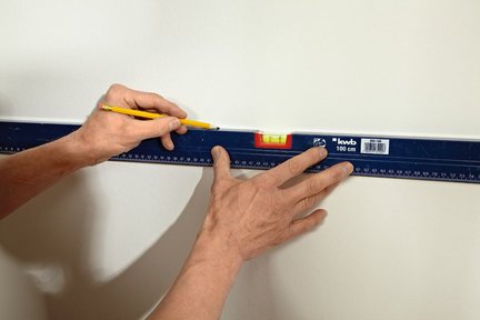 1. Bordiura ma szerokość 2 arkuszy tapet, które przyklejamy jeden nad drugim. Ich pozycje wyznaczamy, rysując linię między górnymi a dolnymi kwadratami.